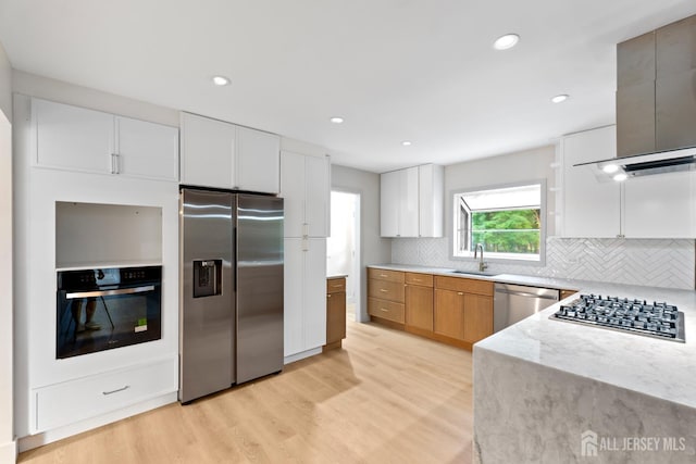 4 Hickory Trl, Flemington, NJ 08822 - kitchen featuring stainless steel appliances, light wood-style flooring, tasteful backsplash, wall chimney exhaust hood, and white cabinetry