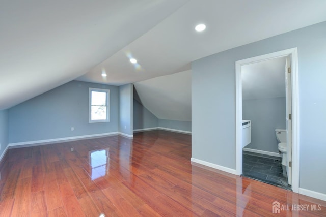 bonus room featuring dark hardwood / wood-style flooring and vaulted ceiling