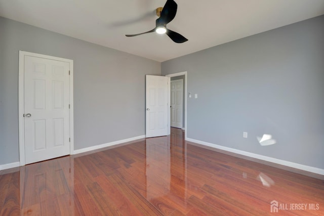 unfurnished bedroom featuring ceiling fan and dark hardwood / wood-style flooring