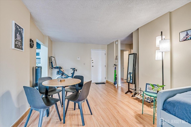 10 N Wood Ave Unit 213, Linden, NJ 07036 - dining area featuring baseboards, light wood finished floors, and a textured ceiling