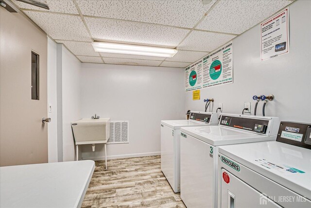 10 N Wood Ave Unit 213, Linden, NJ 07036 - shared laundry room featuring washer and clothes dryer, light wood-type flooring, and baseboards