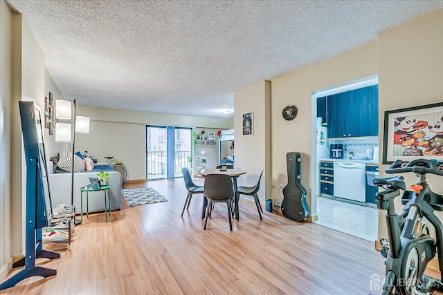 dining area featuring wood finished floors and a textured ceiling