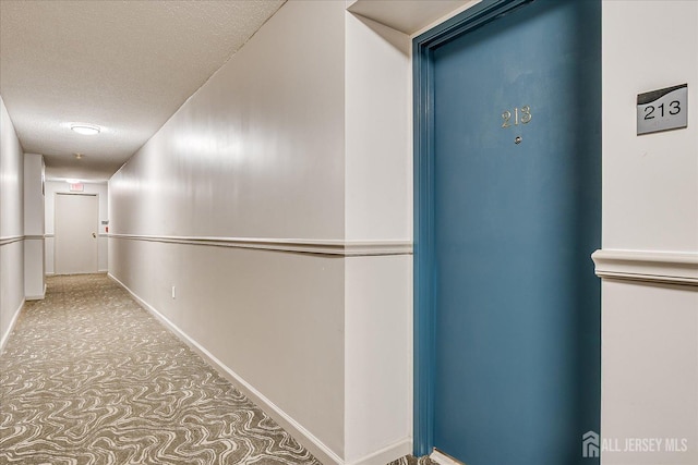 corridor with baseboards and a textured ceiling