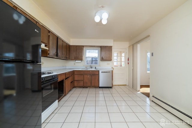 kitchen featuring baseboard heating, dishwasher, light countertops, freestanding refrigerator, and gas range oven