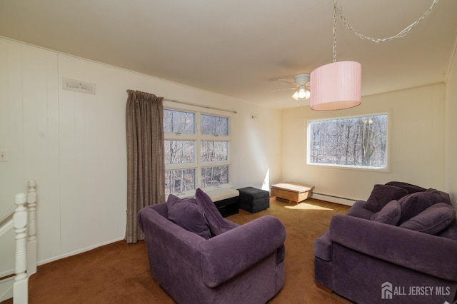 carpeted living room with baseboards, a baseboard radiator, a ceiling fan, and a wealth of natural light