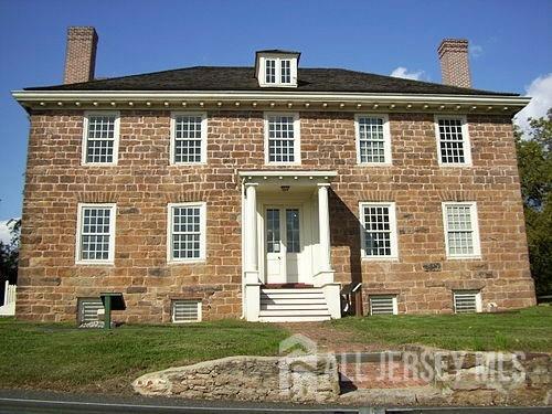back of property with a lawn, a chimney, and french doors