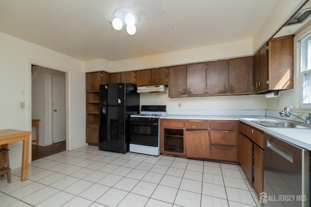 kitchen with stainless steel dishwasher, light countertops, freestanding refrigerator, under cabinet range hood, and gas range oven