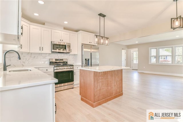 32 Campbell Ave, Edison, NJ 08817 - kitchen with stainless steel appliances, a sink, light wood-type flooring, a kitchen island, and decorative backsplash