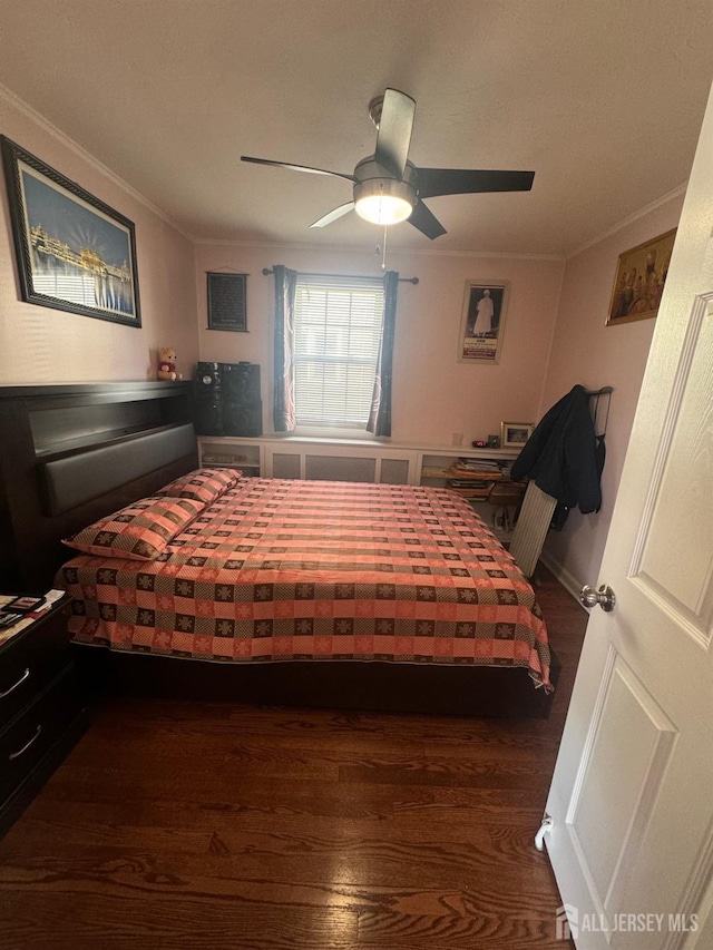 bedroom with a ceiling fan, wood finished floors, and ornamental molding