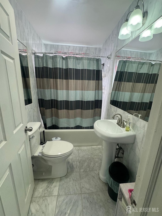 bathroom featuring tile walls, shower / tub combo, and toilet