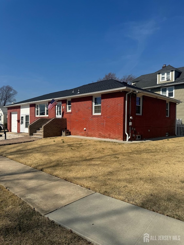 view of front of house with brick siding and a front yard