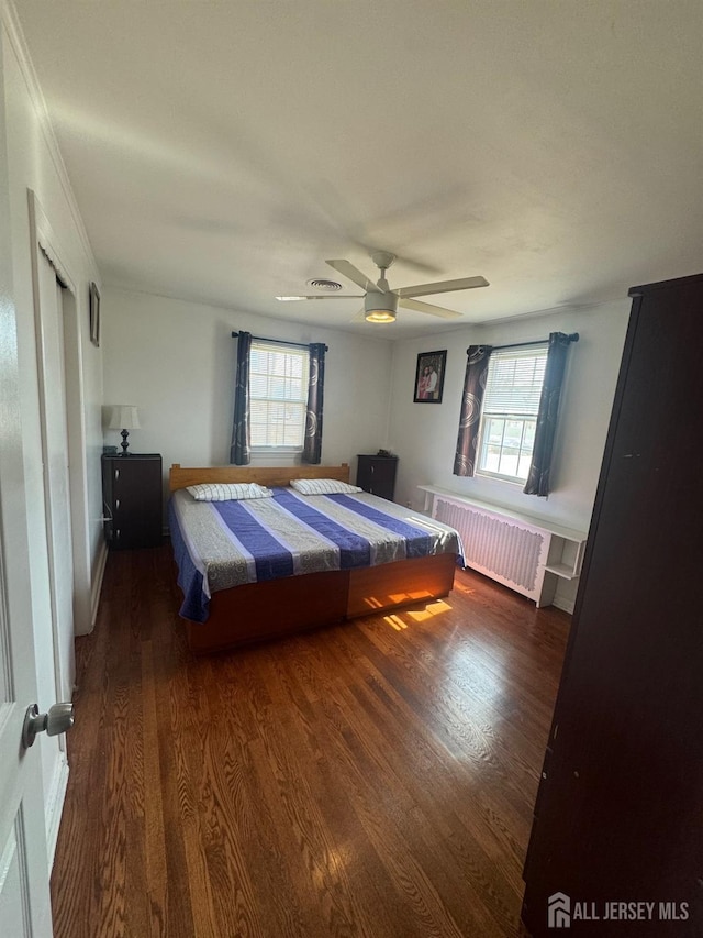 unfurnished bedroom with radiator heating unit, wood finished floors, and ceiling fan