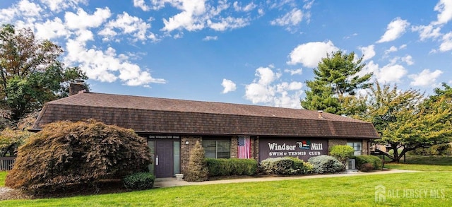 2413 Old Stone Mill Dr, East Windsor, NJ 08512 - dutch colonial featuring a front lawn, a chimney, and roof with shingles