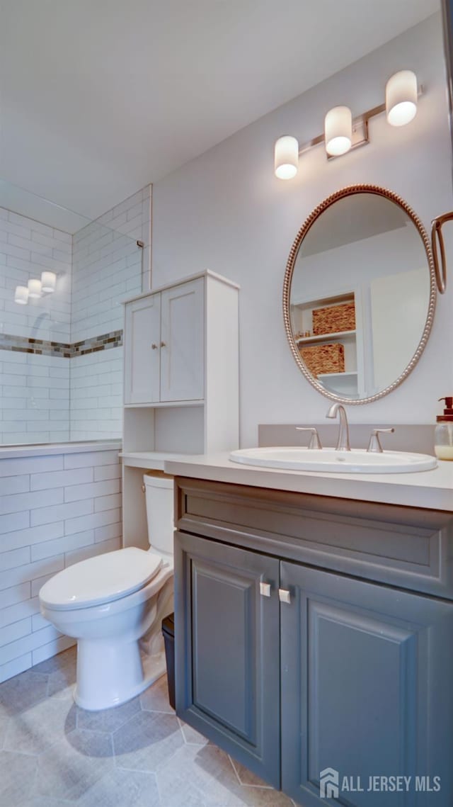 2413 Old Stone Mill Dr, East Windsor, NJ 08512 - full bathroom with vanity, toilet, a tile shower, and tile patterned flooring