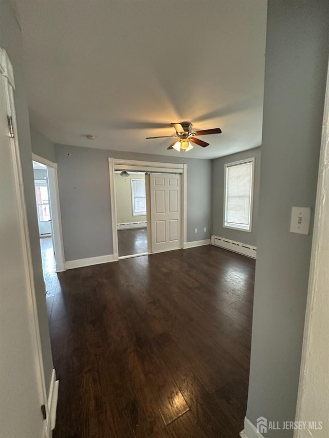 111 Joyce Kilmer Ave, New Brunswick, NJ 08901 - unfurnished room with a baseboard heating unit, dark wood-type flooring, baseboards, a ceiling fan, and baseboard heating