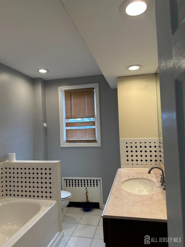 111 Joyce Kilmer Ave, New Brunswick, NJ 08901 - bathroom with radiator, toilet, a garden tub, vanity, and tile patterned flooring