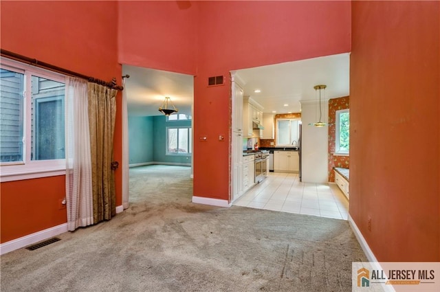 130 Sayre Dr, Plainsboro, NJ 08540 - kitchen featuring light carpet, plenty of natural light, baseboards, and a towering ceiling