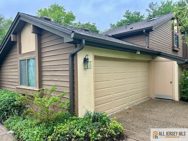 130 Sayre Dr, Plainsboro, NJ 08540 - view of side of property with an attached garage, driveway, stucco siding, and roof with shingles