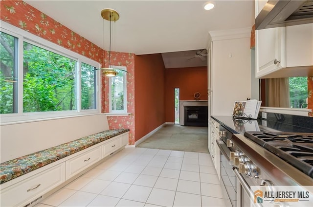 130 Sayre Dr, Plainsboro, NJ 08540 - kitchen featuring wall chimney range hood, stainless steel gas range, light colored carpet, a ceiling fan, and white cabinetry