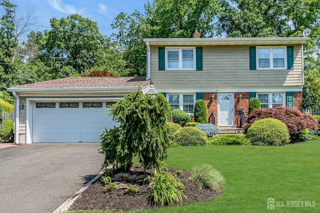 30 Daniel Dr, Matawan, NJ 07747 - colonial inspired home featuring asphalt driveway, a chimney, a front lawn, a garage, and brick siding