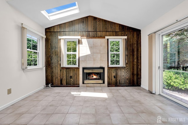 30 Daniel Dr, Matawan, NJ 07747 - unfurnished living room with vaulted ceiling, a skylight, wood walls, a fireplace, and plenty of natural light
