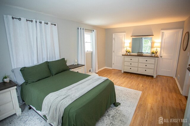 bedroom with wood finished floors and baseboards