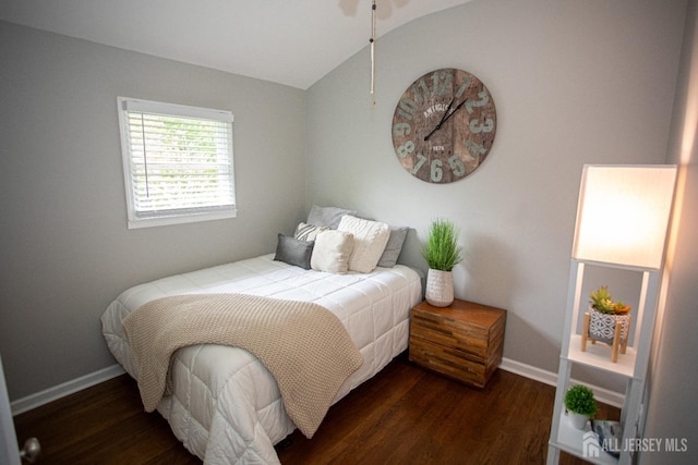 bedroom with baseboards, vaulted ceiling, and dark wood-type flooring