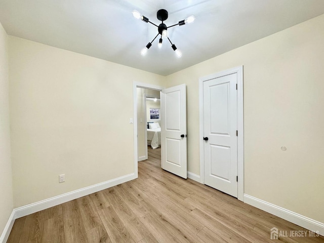 4 Joseph Ct, Old Bridge, NJ 08879 - unfurnished bedroom featuring baseboards, light wood finished floors, and a chandelier