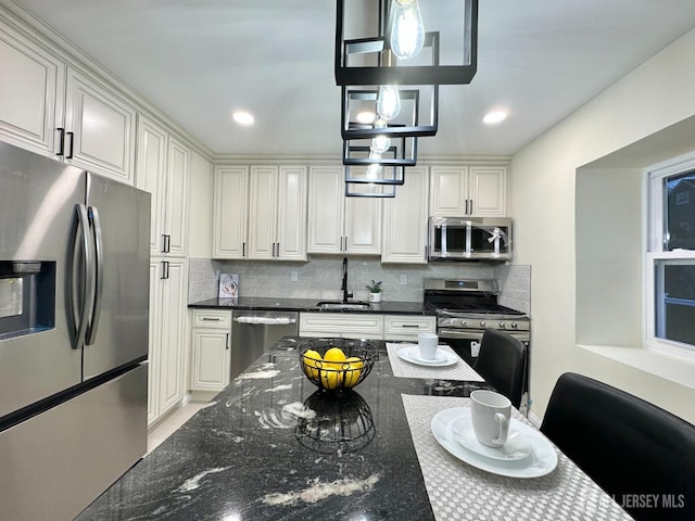 4 Joseph Ct, Old Bridge, NJ 08879 - kitchen with appliances with stainless steel finishes, a sink, tasteful backsplash, dark stone countertops, and hanging light fixtures