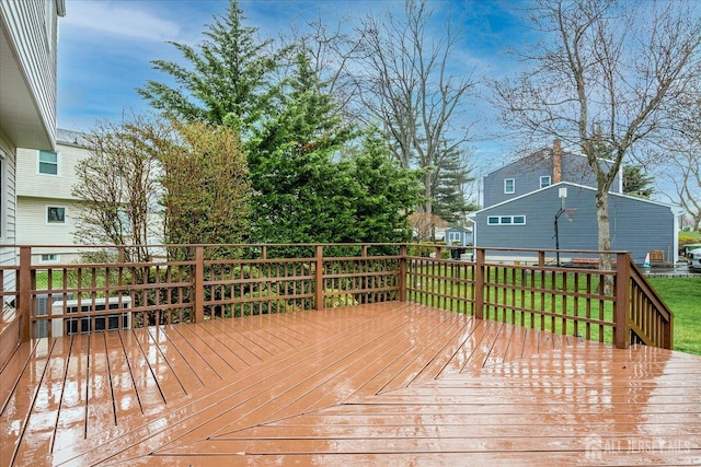 wooden deck featuring a lawn