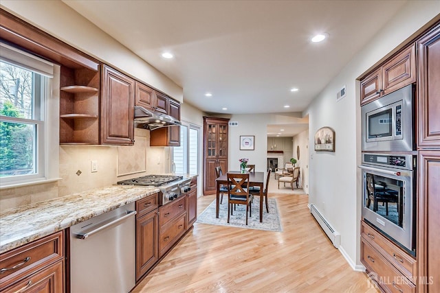kitchen featuring light wood-style flooring, a wealth of natural light, recessed lighting, appliances with stainless steel finishes, and a baseboard radiator