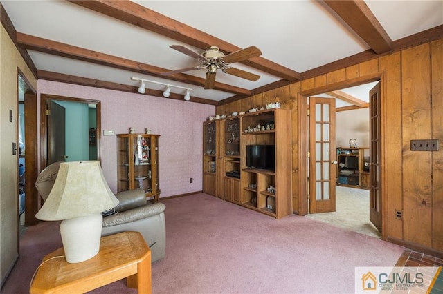 living room with french doors, ceiling fan, wooden walls, beam ceiling, and carpet floors