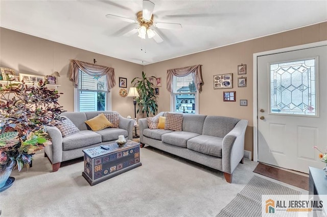 carpeted living room with ceiling fan and plenty of natural light