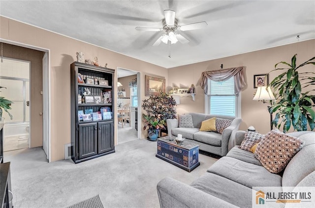 living room with a ceiling fan and carpet