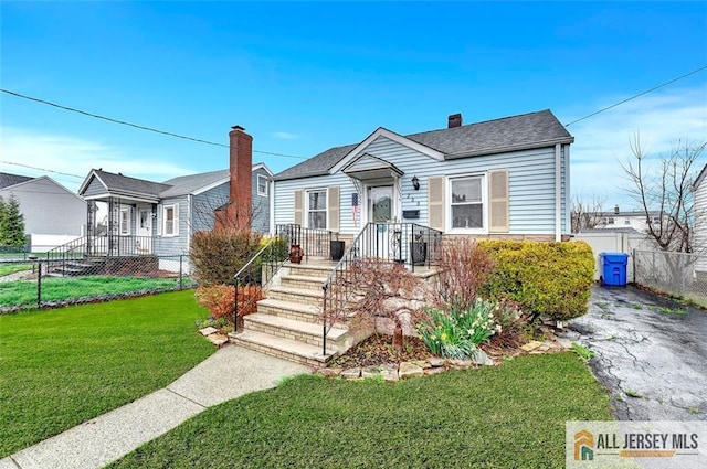 bungalow featuring a chimney, fence, and a front yard