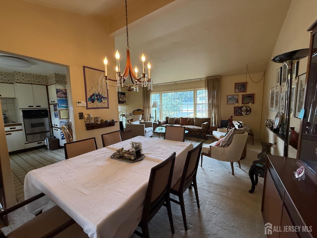 dining space featuring an inviting chandelier and high vaulted ceiling