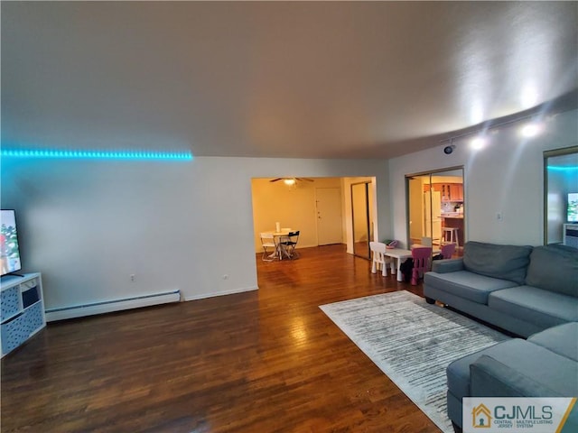 living room with a baseboard heating unit and wood finished floors