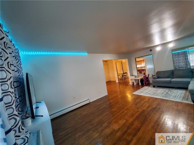 living room featuring baseboards, a baseboard heating unit, and wood finished floors