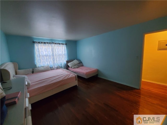 bedroom with baseboards and wood finished floors