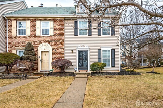 view of front of home with brick siding and a front yard