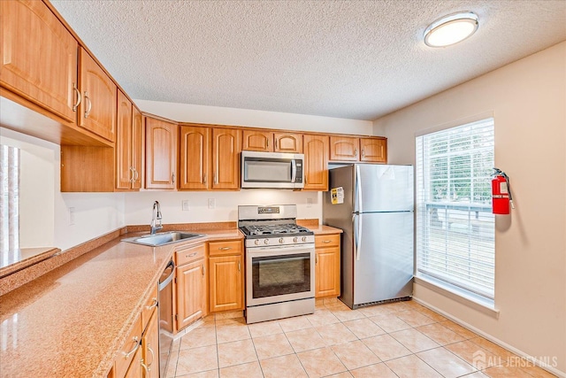 kitchen with light tile patterned floors, brown cabinets, stainless steel appliances, light countertops, and a sink