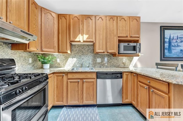 71 Russell St, Woodbridge Proper, NJ 07095 - kitchen featuring appliances with stainless steel finishes, under cabinet range hood, a sink, decorative backsplash, and light tile patterned floors