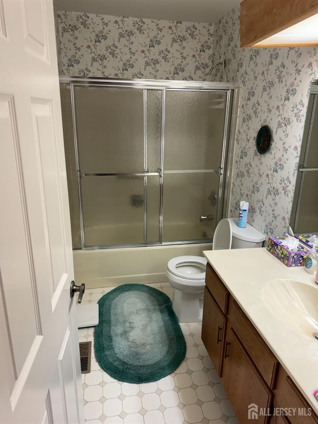 full bath featuring wallpapered walls, toilet, enclosed tub / shower combo, tile patterned floors, and vanity