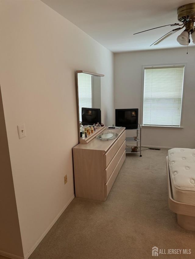 office area with light carpet, ceiling fan, and baseboards