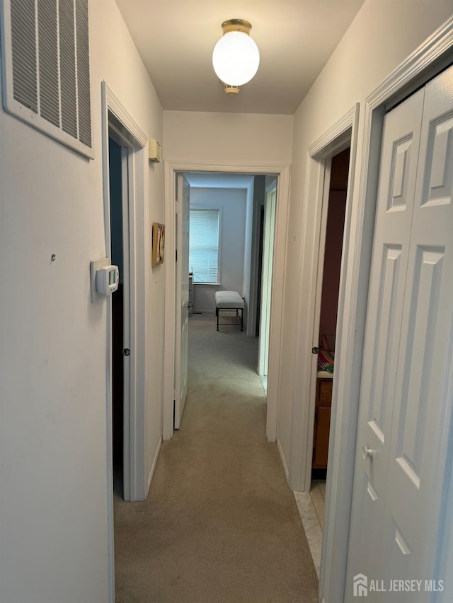 hallway with light carpet and visible vents