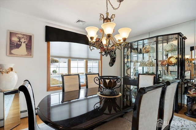 dining room featuring visible vents, an inviting chandelier, a baseboard heating unit, and crown molding