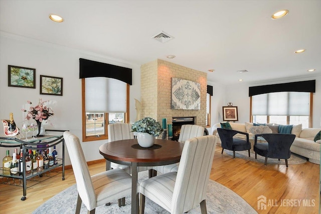 dining area with visible vents, recessed lighting, light wood-style floors, baseboards, and a brick fireplace