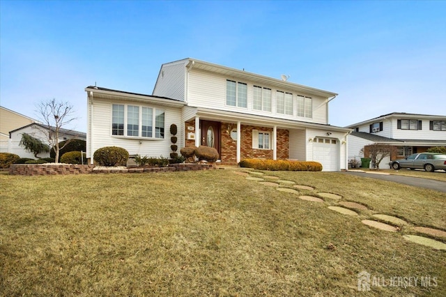 traditional home with a front lawn, aphalt driveway, covered porch, an attached garage, and brick siding