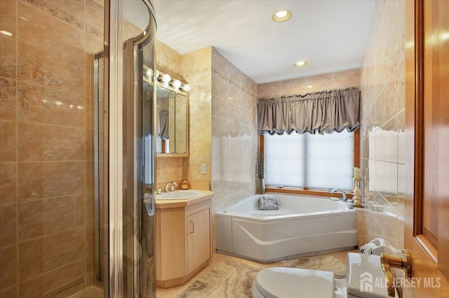 bathroom featuring vanity, toilet, a shower stall, tile walls, and a bath