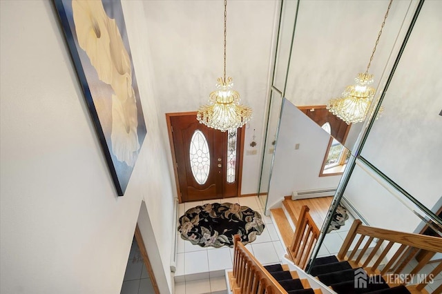 entrance foyer featuring stairway, a notable chandelier, and tile patterned flooring